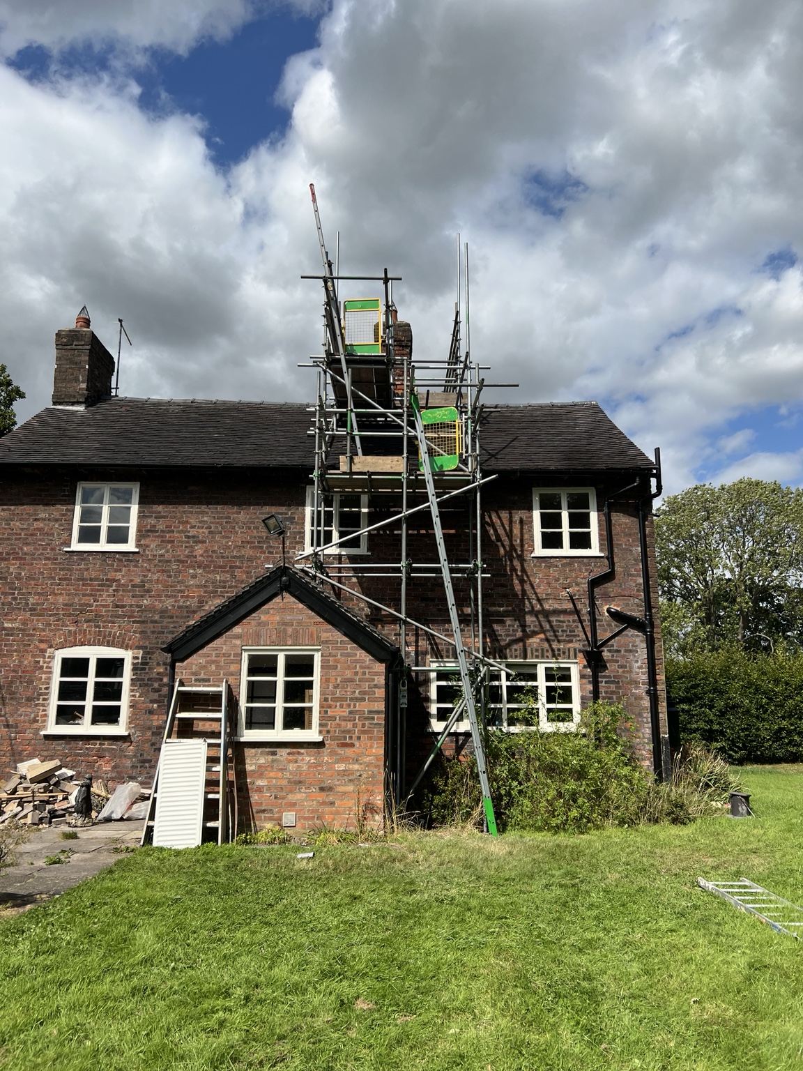 Scaffold tower reaching the chimney above a brick estate building at Arley Hall