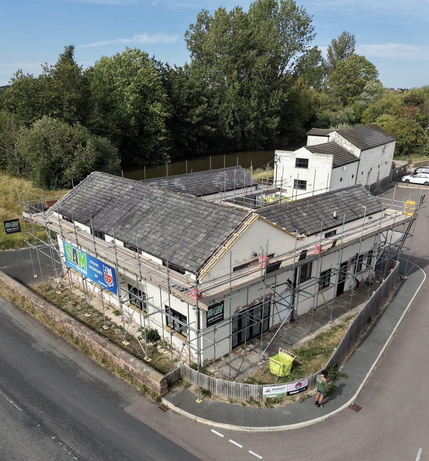 Scaffolding following the corner and side elevation of Kingsley Mill beside the road