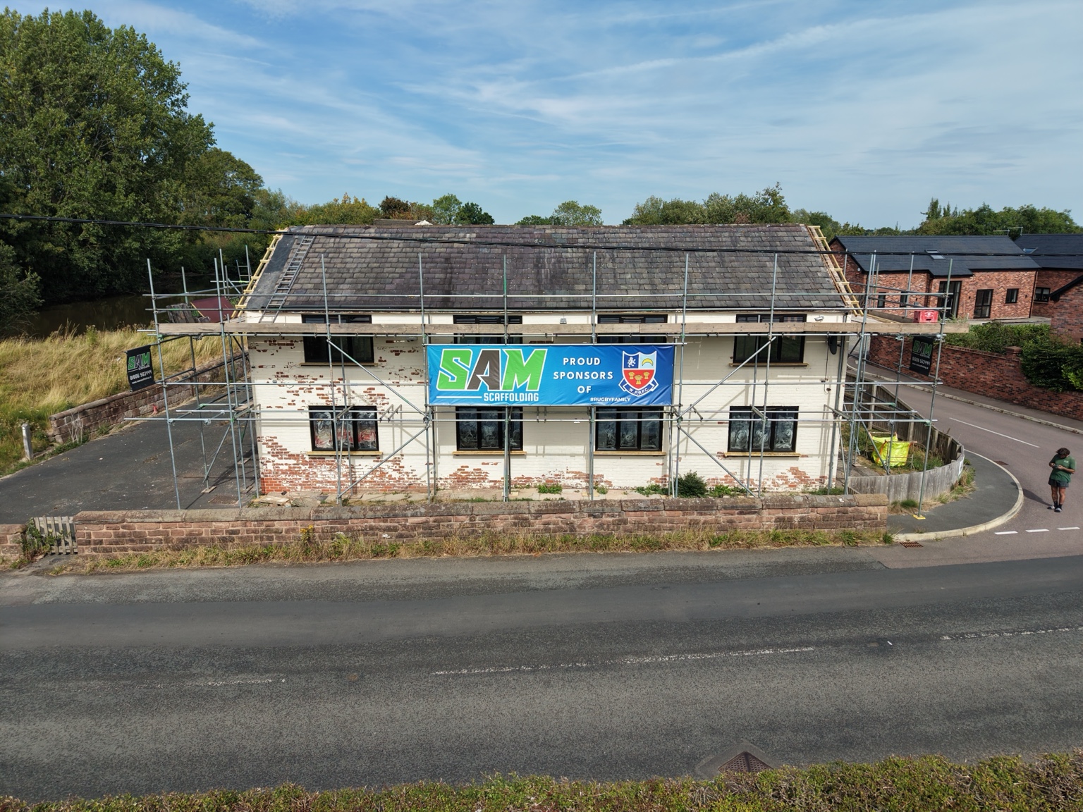Scaffold along the front of Kingsley Mill with the SAM Scaffolding rugby sponsorship banner